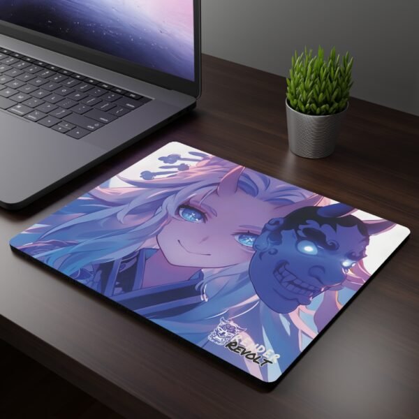 Aiko Demon Oni Mouse Pad featuring a white-haired character with glowing blue eyes, a mischievous smile, and a floating oni mask, placed on a dark wooden desk next to a laptop and plant.