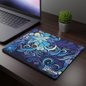 Blue Aurora Mouse Pad - A dark wooden desk setup featuring a laptop and a mouse pad with an intricate floral design in shades of blue, purple, and gold, blending swirling patterns and blooming flowers.