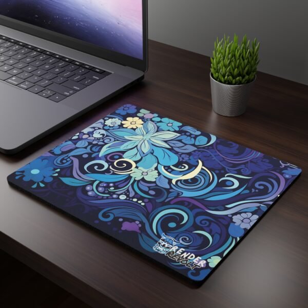 Blue Aurora Mouse Pad - A dark wooden desk setup featuring a laptop and a mouse pad with an intricate floral design in shades of blue, purple, and gold, blending swirling patterns and blooming flowers.