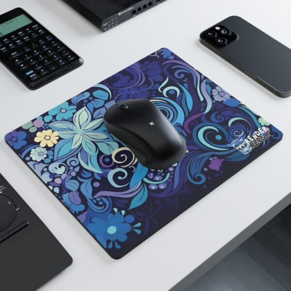 A modern workspace with a black wireless mouse resting on a colorful floral-themed mouse pad, featuring an elaborate mix of swirling blue patterns and intricate floral elements.