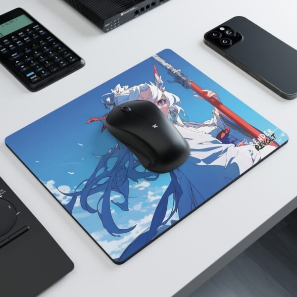 A modern workspace with a black wireless mouse resting on a vibrant anime-style mouse pad, depicting a confident character with silver hair, piercing blue eyes, and a battle-worn spear, dressed in a flowing white robe.