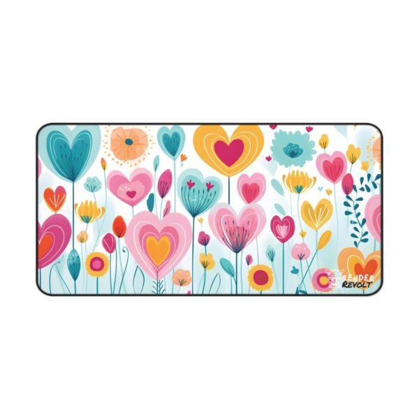 A flat lay of the same desk mat on a black surface, showcasing its bright heart-shaped floral pattern with a white mouse on top.